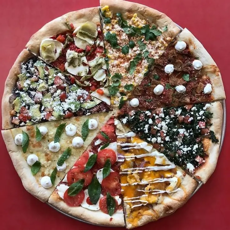 Adding fresh toppings to a pizza base.