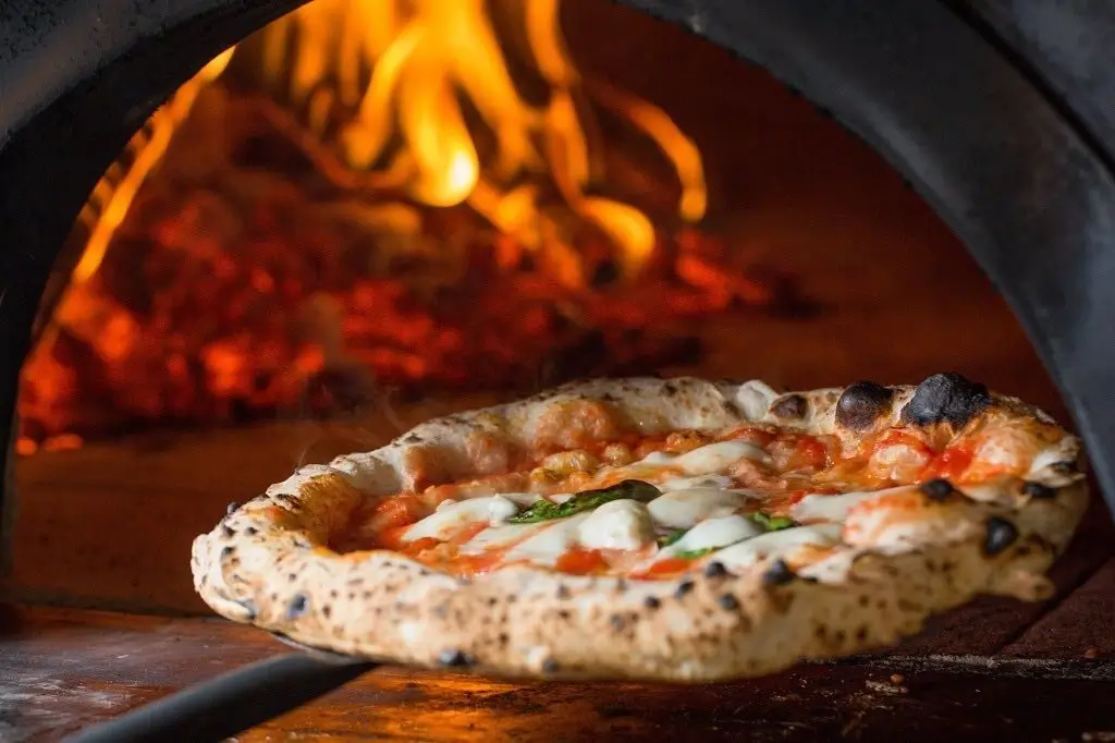 Pizza baking inside the fiery wood oven.