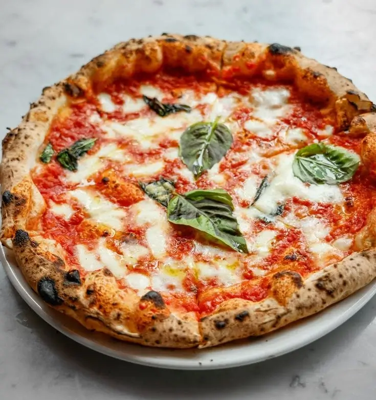 An overhead shot of a finished Margherita pizza.
