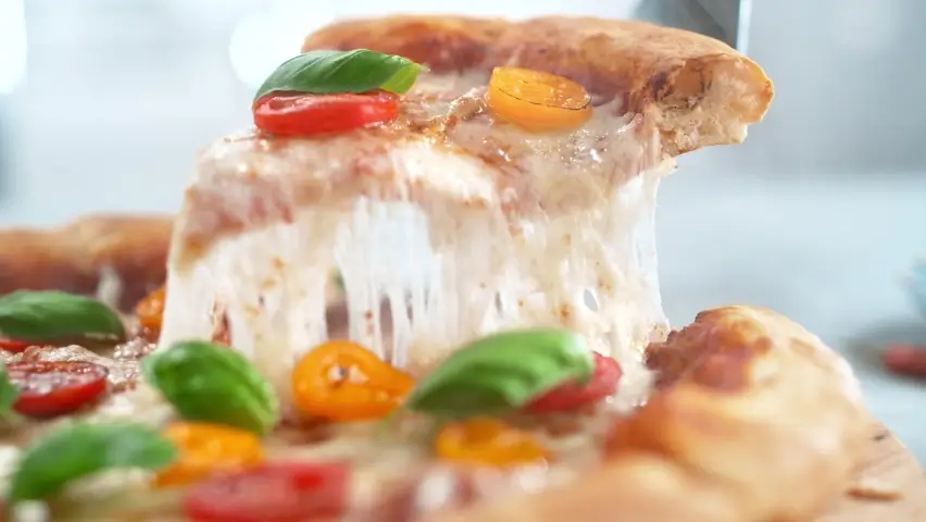 A slice of pizza being lifted, showing melted cheese.