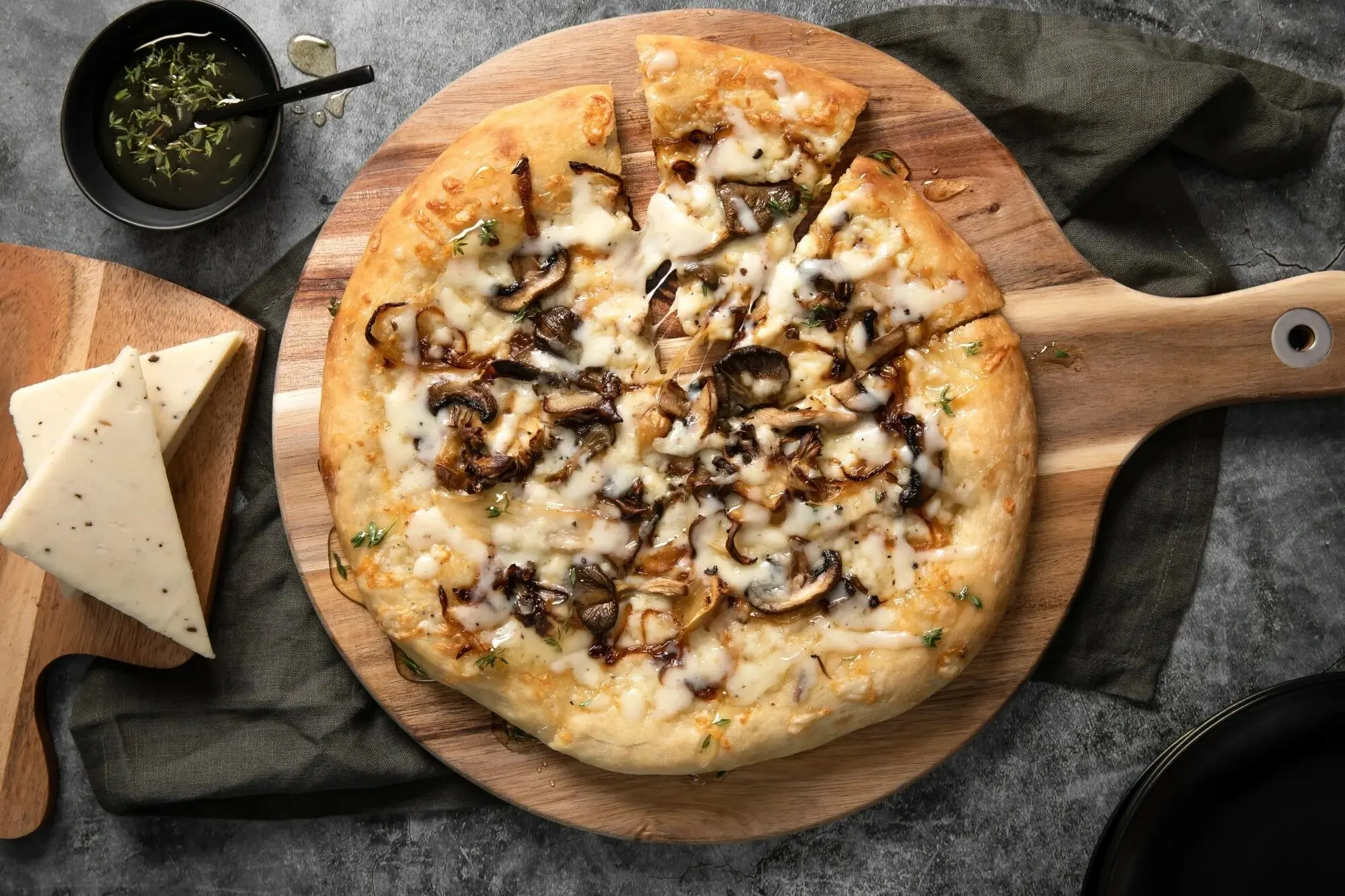A pizza topped with wild mushrooms, truffle oil, and herbs.