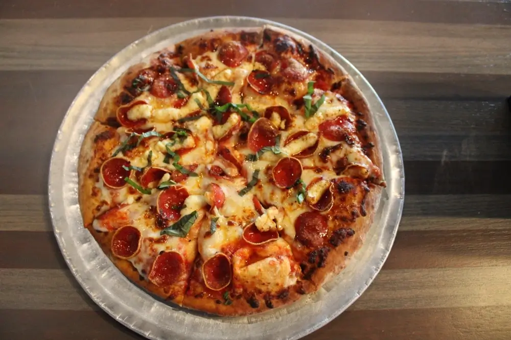 A spicy pepperoni pizza with chili flakes and hot honey.